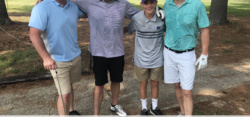 Four golfers posing at memorial benefit tournament