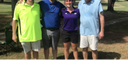 Four golfers posing together at golf tournament